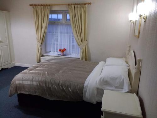 A bed or beds in a room at Chadwick House Hotel