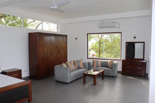 a living room with two couches and a coffee table at Hotel Paradiso, in Unawatuna