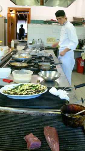 a chef standing in a kitchen with a plate of food at Tenuta Le Sorgive Agriturismo in Solferino