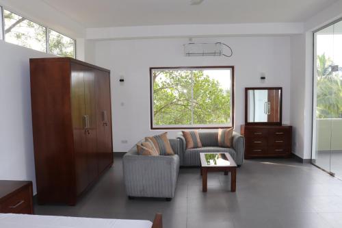 a living room with a couch and a table at Hotel Paradiso, in Unawatuna
