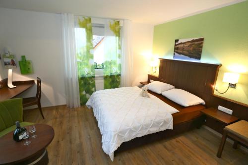 a bedroom with a large white bed and a desk at Wein-Träume in Thüngersheim