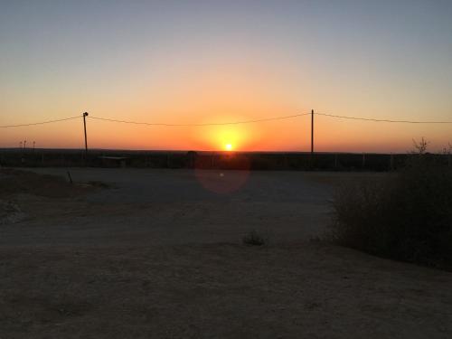a sunset in the desert with the sun setting at צימר מול השקיעה in Retamim