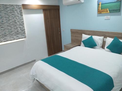 a bedroom with a bed with blue and white at TJ Boutique in Marsaskala