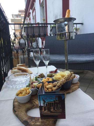 a table with a tray of food and wine glasses at Il vecchio Fauno in Pompei