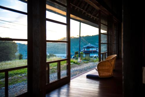 a room with a window with a chair in front of it at Setouchi Cominca Stays Hiroshima Chojaya in Shōbara