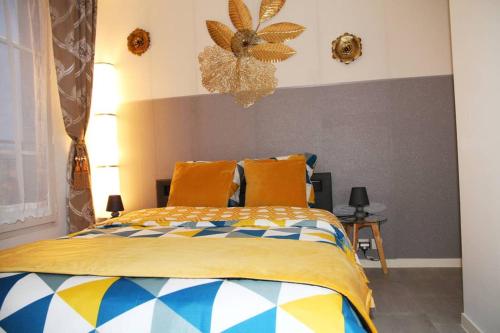 Schlafzimmer mit einem Bett mit gelber und blauer Decke in der Unterkunft Monyhome, Appt 4pers 5mn walk RER A et Mall Val d'Europe-Disney in Chessy