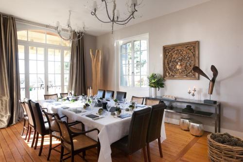 une salle à manger avec une longue table et des chaises dans l'établissement Villa La Tosca, à Lanton