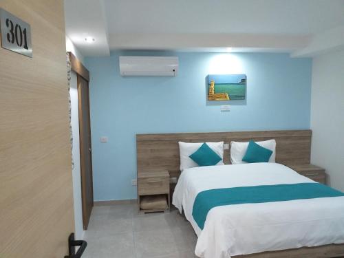 a bedroom with a bed and a blue wall at TJ Boutique in Marsaskala