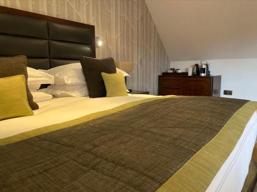 a bedroom with a large bed with yellow pillows at Great Fosters - Near Windsor in Egham