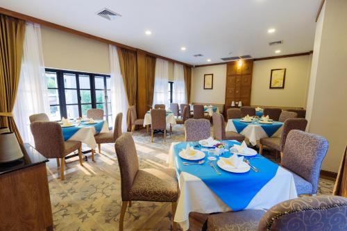 a dining room with blue tables and chairs at Decharme Hotel in Chiang Mai