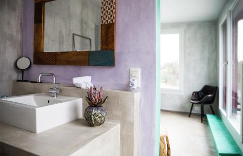 a bathroom with a white sink and a mirror at No1 Art B&B in Au