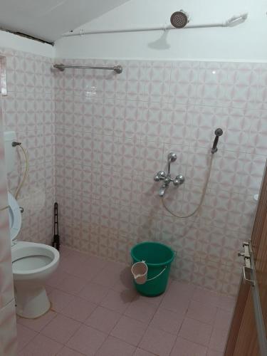 a bathroom with a shower with a toilet and a bucket at Om Shanti Beach Stay Patnem in Patnem