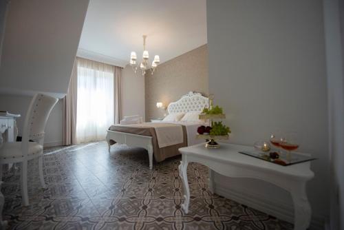a bedroom with a bed and a table and a chandelier at Sui Generis Tropea Luxury Rooms in Tropea