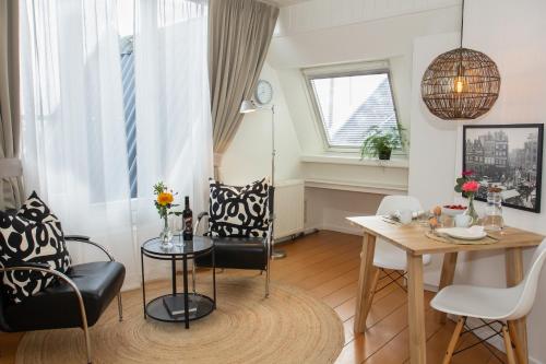 a dining room with a table and chairs and a window at Apartments Waterland in Monnickendam