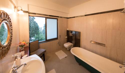 uma casa de banho com uma banheira, um lavatório e um WC. em Sourenee Tea Estate em Mirik