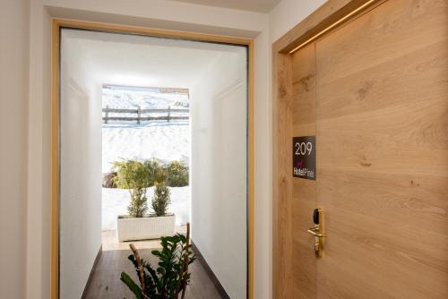 a door leading into a room with a window at Hotel Pinei in Ortisei