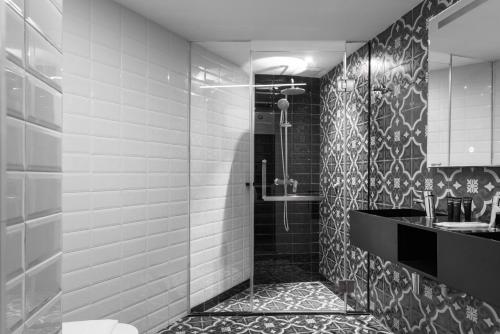 a black and white bathroom with a shower and a sink at Loop On Leith George Town Penang Hotel in George Town