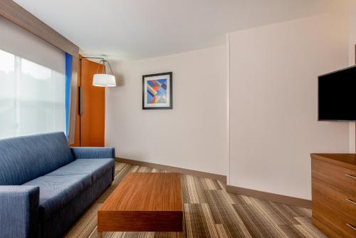 a living room with a couch and a tv at Holiday Inn Express Chapel Hill by IHG in Chapel Hill