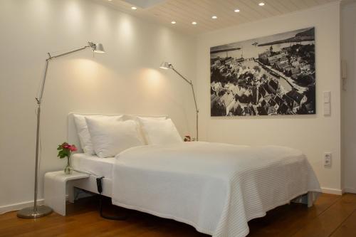 Un dormitorio con una cama blanca con una foto en la pared en Apartments Waterland, en Monnickendam