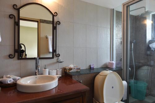 a bathroom with a sink and a mirror at Sourenee Tea Estate in Mirik