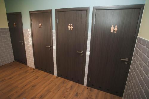 a row of brown doors in a room with wooden floors at DREAM Hostel Khmelnytskyi in Khmelʼnytsʼkyy