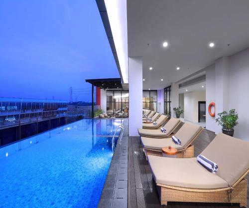 un hotel con una piscina con tumbonas en Quest Prime Cikarang by ASTON en Bekasi
