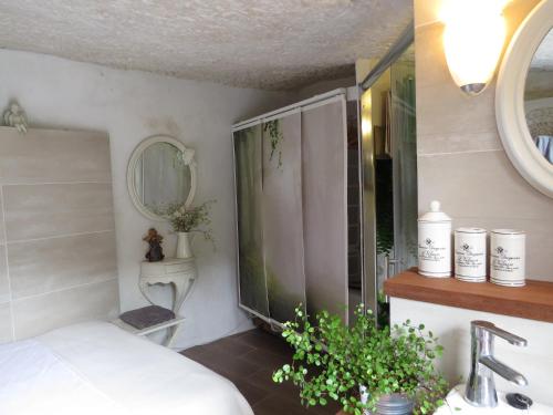 a bathroom with a bed and a sink and a mirror at La cueva de Ángel B&B in Firgas