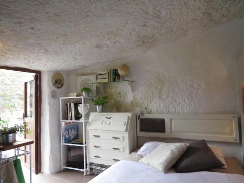 sypialnia z łóżkiem i białą komodą w obiekcie La cueva de Ángel B&B w mieście Firgas