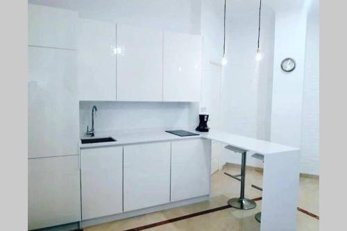 - une cuisine blanche avec un évier et un bureau dans l'établissement Coqueto Apartamento en el Arenal, Centro, à Séville