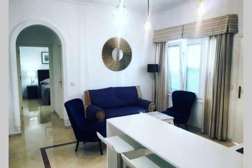 - un salon avec un canapé bleu et des chaises dans l'établissement Coqueto Apartamento en el Arenal, Centro, à Séville