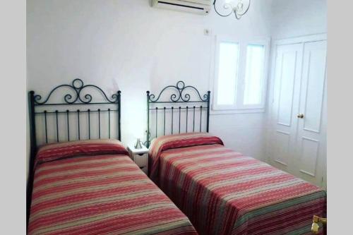 - deux lits assis l'un à côté de l'autre dans une pièce dans l'établissement Coqueto Apartamento en el Arenal, Centro, à Séville
