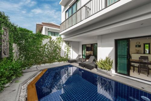 a swimming pool in front of a house at Thaimond Residence by TropicLook Walkable distance to Naiharn beach in Nai Harn Beach