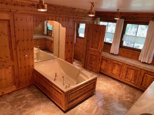 a large bathroom with a tub and a mirror at Schwarzwald-Villa mit Indoor-Pool in Feldberg