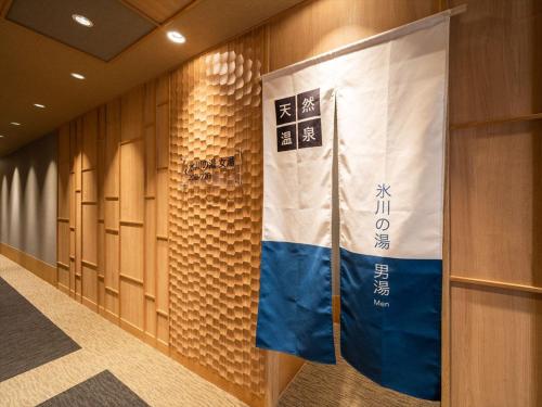 a flag is hanging on a wall in a locker room at Super Hotel Premier Saitama Higashiguchi in Saitama