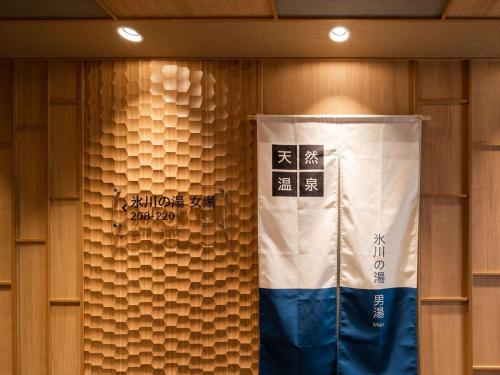 a wall with a flag in a room with wooden walls at Super Hotel Premier Saitama Higashiguchi in Saitama
