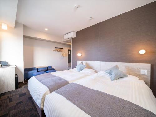 a hotel room with two beds in a room at Super Hotel Premier Saitama Higashiguchi in Saitama