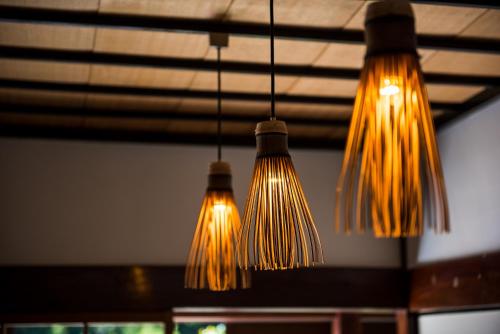 a group of lights hanging from a ceiling at せとうち古民家ステイズHiroshima 不老仙 in Shōbara