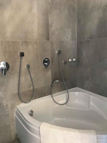 La salle de bains est pourvue d'une baignoire avec deux pommeaux de douche. dans l'établissement Villa les Pierres d'Antan, à Lorgues