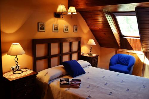 a bedroom with a bed and a blue chair at Apartaments El Tarter in Erill la Vall