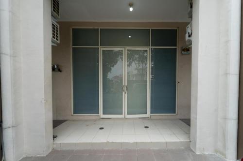 a large glass entry door to a building at KoolKost Syariah at Green Lake City in Gondrong