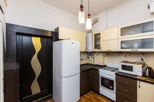a kitchen with a white refrigerator and a stove at Квартира подобово біля Площі Ринок вулиця Староєврейська 17 in Lviv
