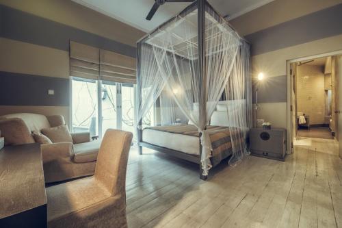a bedroom with a canopy bed and a couch at Paradise Road Tintagel Colombo in Colombo