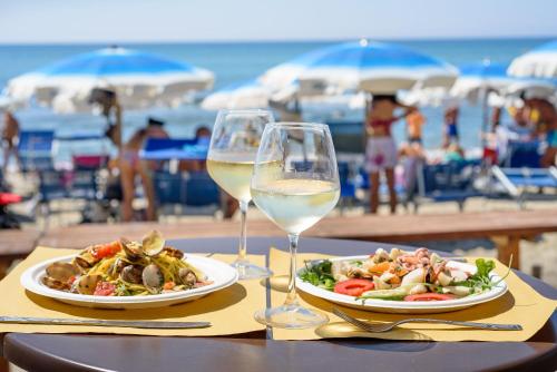 a table with two glasses of wine and a plate of food at Villaggio Orizzonte in Riotorto