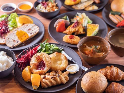 Super Hotel Premier Saitama Higashiguchi في سايتاما: طاولة خشبية عليها صحون طعام