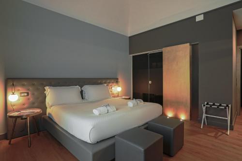 a bedroom with a large white bed and a table at Palco Noir! in Palermo