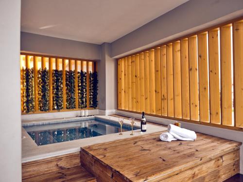 a room with a swimming pool with a wooden tub at Savvas Luxury Suites in Laganas