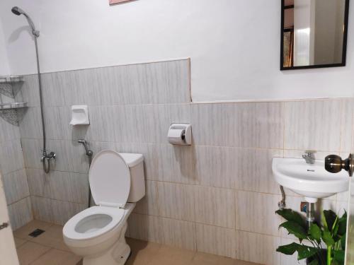 a bathroom with a toilet and a sink at NoBi's Inn, Port Barton in San Vicente