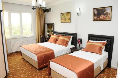 a bedroom with two beds and a window at Hotel Kuk in Istanbul