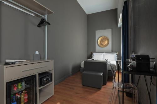 Kleines Zimmer mit einem Bett und einem TV in der Unterkunft Palco Noir! in Palermo