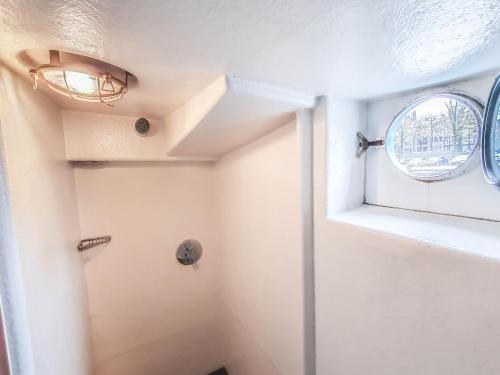 a bathroom with a shower and a window at Amsterdam Hotelboat in Amsterdam